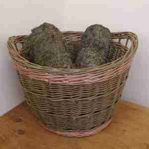 Large olive green round willow log baskets with two buff coloured bands and handles under the rim, with logs inside