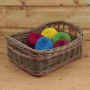 Olive green rectangular storage basket willow basket with two buff coloured bands and handles under the rim, inside are bright wool balls